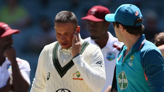 Usman Khawaja leaves the field after being hit on the jaw by a bouncer in Adelaide on Friday.