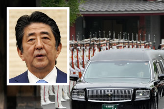 The vehicle carrying the body of former Japanese Prime Minister Shinzo Abe (inset) leaves Zojoji temple after his funeral in Tokyo on July 12.