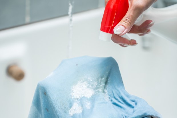 Woman Using Cleaning Product To Clean Stained Textile.