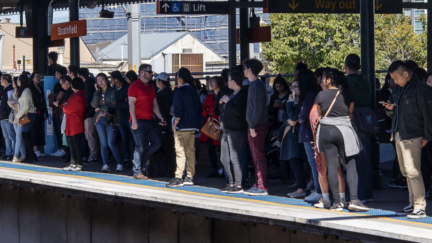Travellers wait for trains at Strathfield station on Saturday.