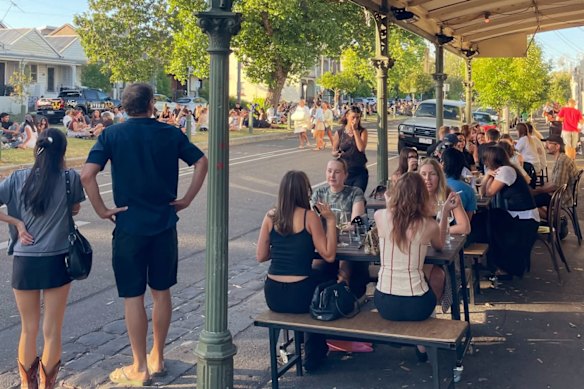 Patrons at the Wine Corner Store and on the nature strip on Canning Street in Carlton North. 