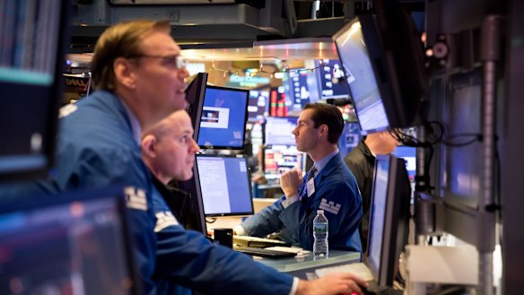 Traders on the floor of the New York Stock Exchange. Stocks have surged on the news of the partial trade deal.