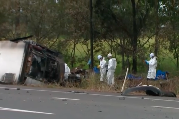 Investigators at the scene of the fiery Bruce Highway crash on Saturday.