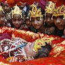 Schoolgirls dressed as Radha, the consort of Hindu Lord Krishna, look at a child dressed as Krishna during the celebrations to mark Janmashtami festival, in Ahmedabad, India