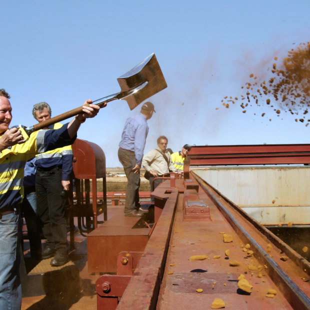 Forrest throws the first shovel-load of iron ore onto a China-bound ship in 2008. 