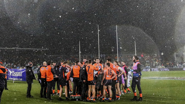 Snow falls on the ground during the game between GWS and Hawthorn in Canberra. 