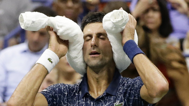 Hot and humid: Novak Djokovic at a change of ends with bags of ice.
