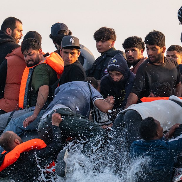 Migrants board a small boat bound for the UK off the shoreline of Gravelines beach in Calais, France on July 17.