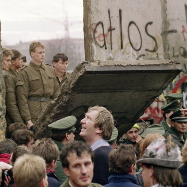 West Berliners watch East German border guards open up a new crossing point in the Berlin Wall in 1989.