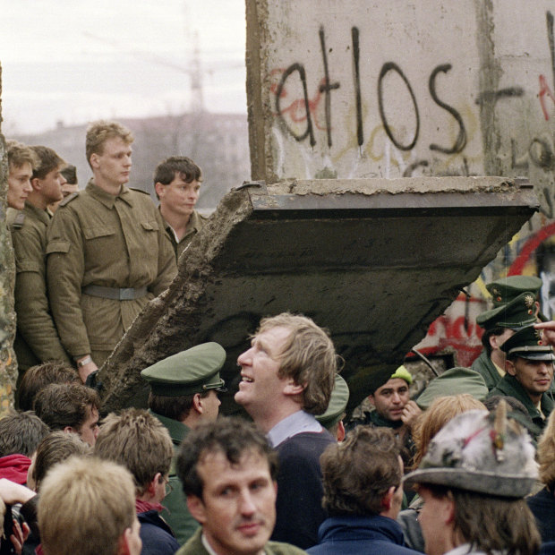 West Berliners watch East German border guards open up a new crossing point in the Berlin Wall in 1989.