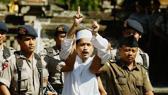 Imam Samudra leaves court after Melbourne man Jan Laczynski held an Australian flag up and asked him to say sorry to Australians.