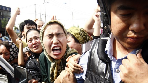 An angry crowd of Uighur Muslims jostle police during protests in Urumqi in 2009. 