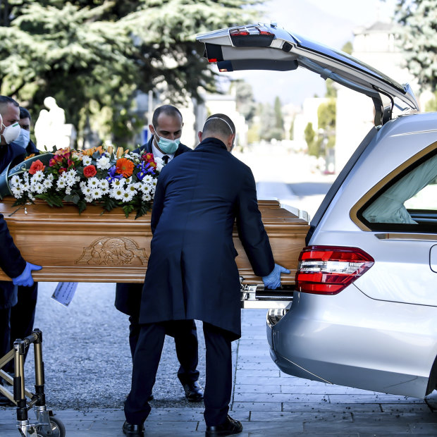 Undertakers carry a coffin out of a hearse at Bergamo's cemetery, northern Italy. 