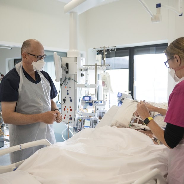 Intensive care director Chris MacIsaac checks a patient with other staff.