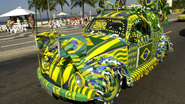 A Volkswagen Beetle, known as Fusca in Brazil, drives around Rio de Janeiro painted in the Brazilian colours during the 2002 FIFA World Cup.