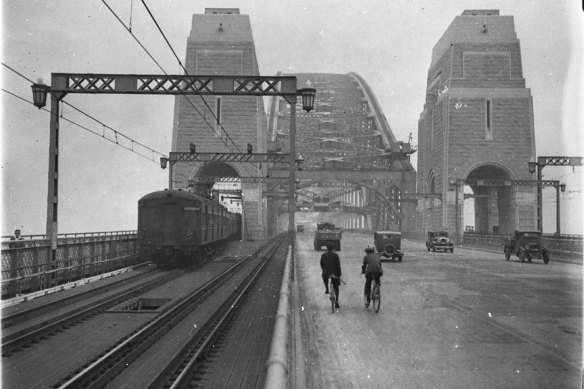 The first cars, trains and bikes cross the Sydney Harbour Bridge in 1932, with no lane markings. 