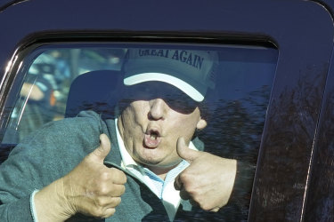 US President Donald Trump gives two thumbs up to supporters as he departs after playing golf at the Trump National Golf Club on November 8.