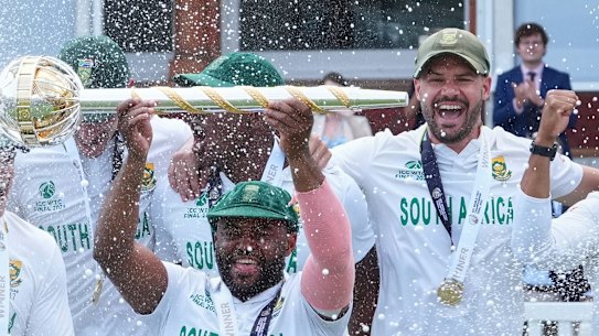 South Africa’s captain Temba Bavuma holds the winner’s trophy and celebrates with teammates after their win in the World Test Championship final against Australia at Lord’s.