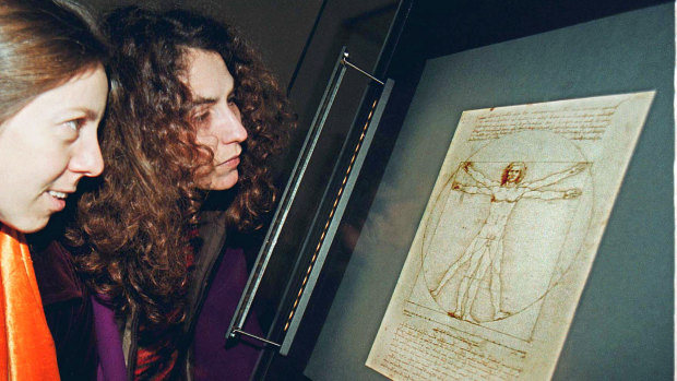 Two women looking at the original of Leonardo da Vinci's Vitruvian Man on display in Venice's Gallerie dell'Accademia in 2002. 