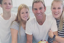 Warne with his three children.