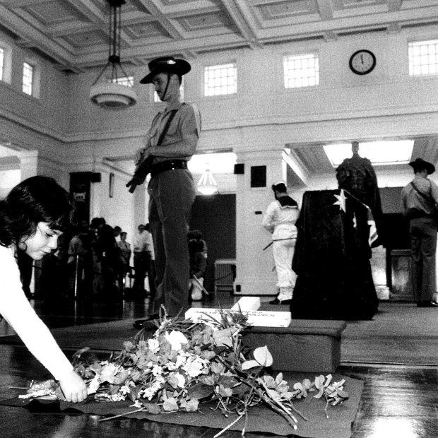 Zoe Sander lays a flower at the coffin of the unknown soldier in Kings Hall at Old Parliament House.