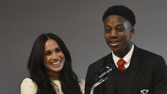 Meghan, Duchess of Sussex, smiles as head boy Aker Okoye, speaks in a school assembly, during her surprise visit to the Robert Clack Upper School in Dagenham, in east London, to celebrate International Women's Day.