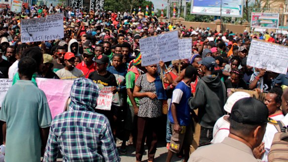 Papuans hold posters during a protest in Timika, Papua province.