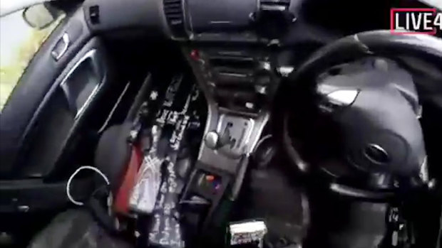 A screenshot from the alleged gunman's video showing the high-powered weapons used in the attack on his front passenger seat.