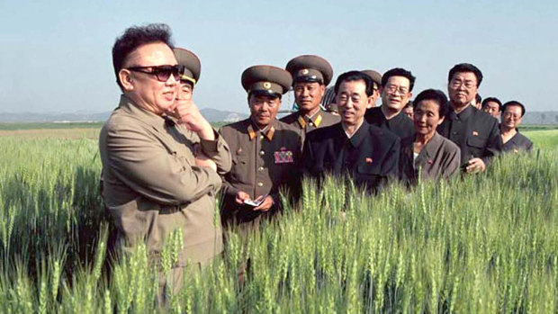 North Korea's then leader Kim Jong-il, left,  visits a farm with officials in 2003.