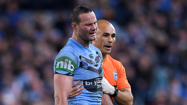 Struggling: Boyd Cordner is assisted from the field by a trainer during Origin II.