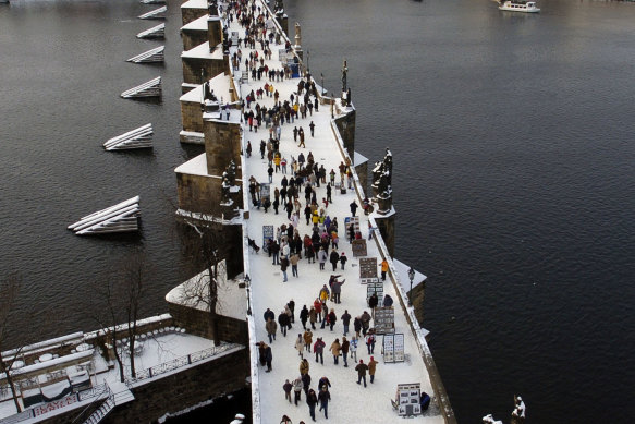 Snow blankets the Charles Bridge in Prague.