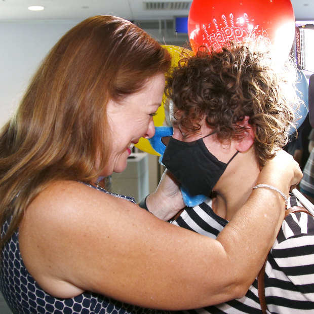Natalie Auchterlonie, left, welcomes her daughter Katherine at the Brisbane Airport after the Queensland borders reopened to Victoria and Greater Sydney.