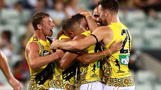 DARWIN, AUSTRALIA - AUGUST 22: Daniel Rioli of the Tigers celebrates with team mates after scoring a goal during the round 13 AFL match between the Essendon Bombers and the Richmond Tigers at TIO Stadium on August 22, 2020 in Darwin, Australia. (Photo by Daniel Kalisz/Getty Images)