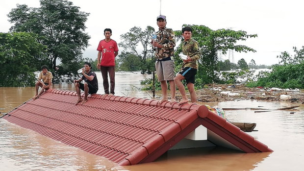 Floods are an international problem: Laotians villagers stranded on a roof of a house due to floodwaters after a dam collapsed. 