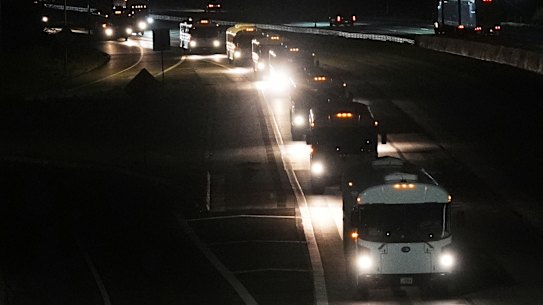 A convoy of buses moves along Interstate Highway 10 after leaving the Marine Corps base in Twentynine Palms, California.