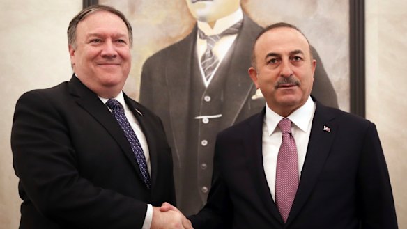 Turkey's Foreign Minister Mevlut Cavusoglu, right, and US Secretary of State Mike Pompeo shake hands before a meeting at the Esenboga Airport in Ankara, Turkey.