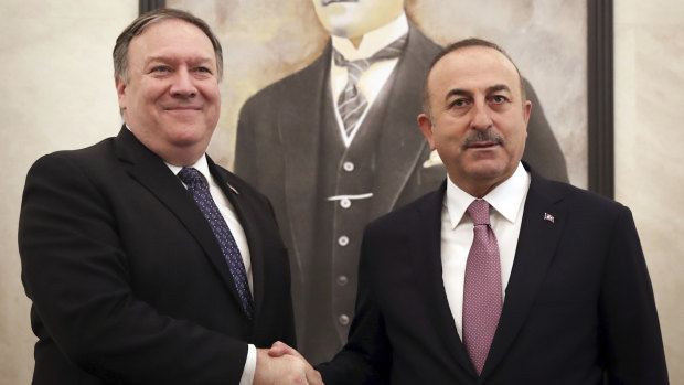 Turkey's Foreign Minister Mevlut Cavusoglu, right, and US Secretary of State Mike Pompeo shake hands before a meeting at the Esenboga Airport in Ankara, Turkey.
