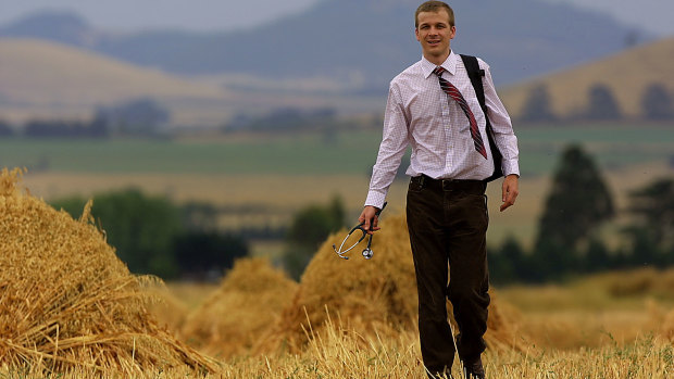 Rural doctor Nathan Grills walks through a paddock of stacks of sheaf hay in the Ascot area north  of Ballarat.