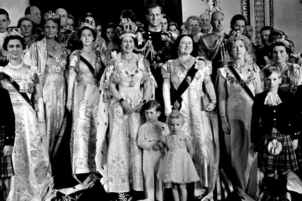 Queen Elizabeth II in her coronation robes with her sister Margaret (left of her), husband and mother (right), children Charles and Anne, and other family members in 1953.