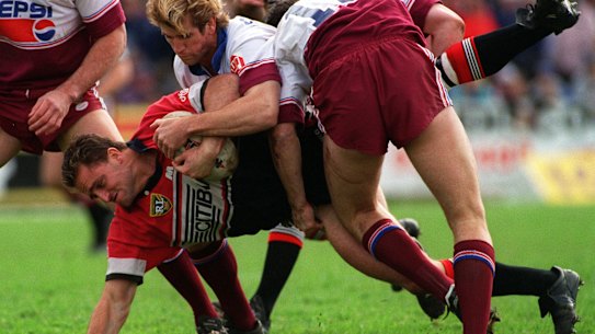 North Sydney enforcer Billy Moore is driven into the Brookvale turf by Manly’s Des Hasler in 1995.