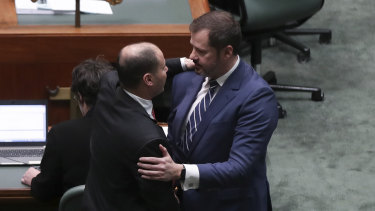 Josh Frydenberg and Ed Husic embrace on the floor of Parliament after condemning Fraser Anning's speech.