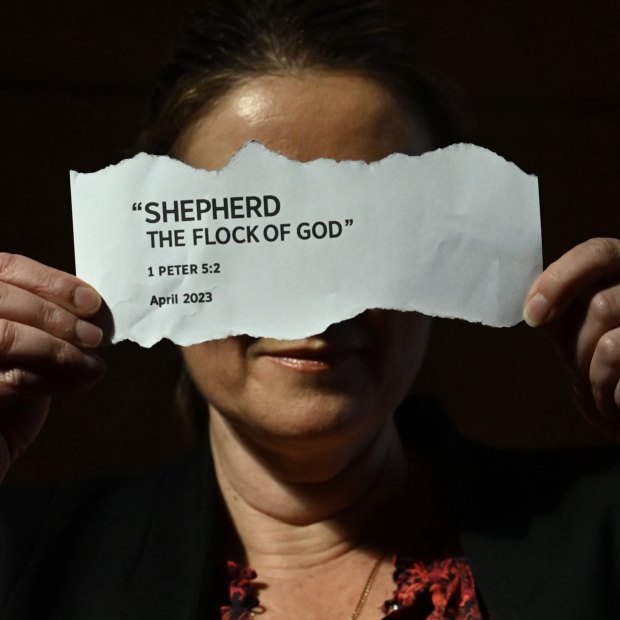 A former Jehovah’s Witness holding a tear out of the 2023 handbook titled “Shepherd The Flock of God”.
