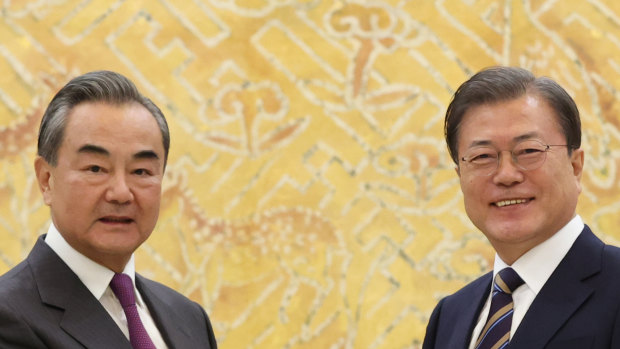 South Korean President Moon Jae-in, right, poses with Chinese Foreign Minister Wang Yi for a photo before a meeting at the presidential Blue House in Seoul.