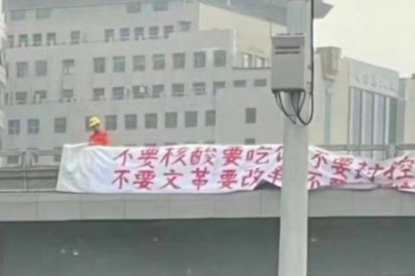 Brave protest: Peng Lifa with his banners on the Beijing overpass last week.