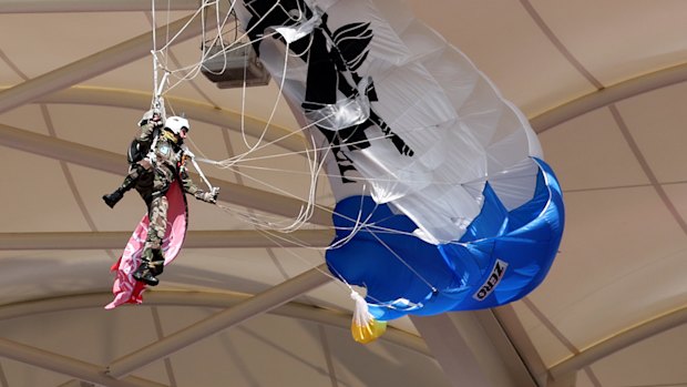 The paratrooper hangs from the stadium roof.