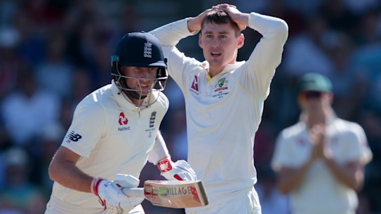 Australia's Marnus Labuschagne, centre, reacts as England's Joe Root, left, takes a run.