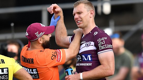 Tom Trbojevic grimaces while having his shoulder assessed after injuring it against the Titans.