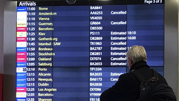 A passenger checks an arrivals board at Gatwick Airport. Flights had returned to normal by Sunday.