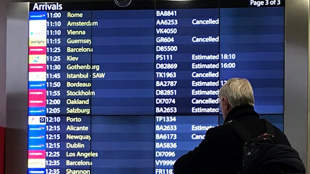 A passenger checks an arrivals board at Gatwick Airport. Flights had returned to normal by Sunday.