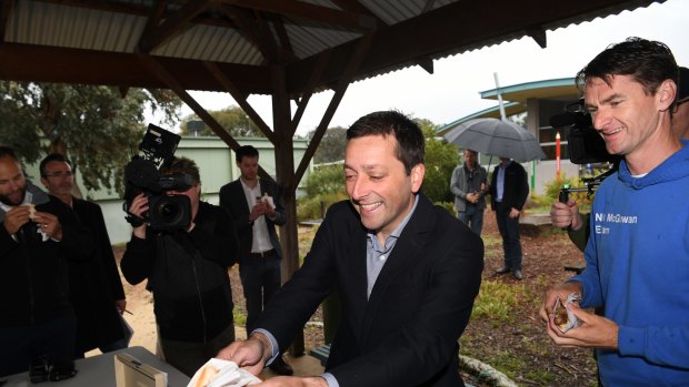 Victorian Opposition Leader Matthew Guy gets a sausage on the final day of the Victorian election campaign, in Melbourne.
